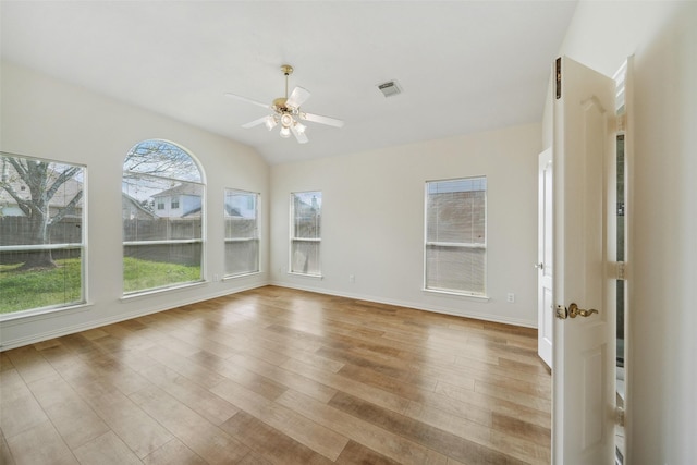 empty room with light wood-type flooring, visible vents, baseboards, ceiling fan, and vaulted ceiling