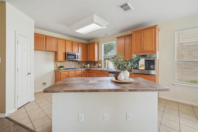 kitchen with tasteful backsplash, light tile patterned floors, visible vents, and appliances with stainless steel finishes