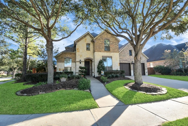 view of front of property with stone siding, concrete driveway, a garage, and a front yard