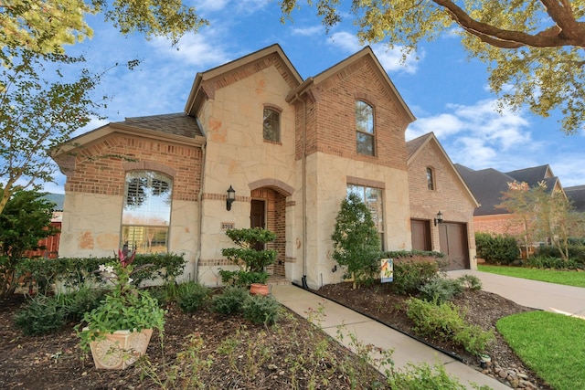 view of front of house featuring concrete driveway, a garage, brick siding, and stone siding