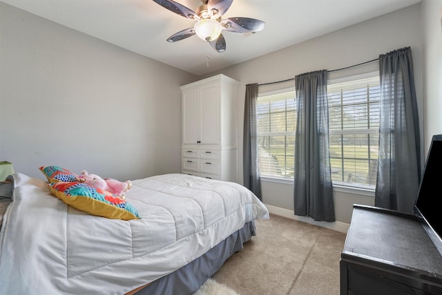 bedroom with light colored carpet, baseboards, and ceiling fan