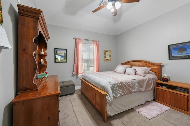 bedroom with visible vents, light carpet, a ceiling fan, a tray ceiling, and baseboards