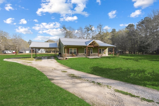 view of front of home with a front lawn, a porch, dirt driveway, metal roof, and a carport