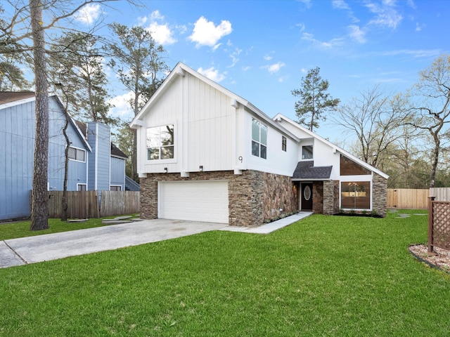 view of front of house featuring a front lawn, fence, concrete driveway, stone siding, and an attached garage