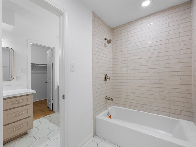 full bath with tile patterned floors, a walk in closet, vanity, baseboards, and shower / bathtub combination