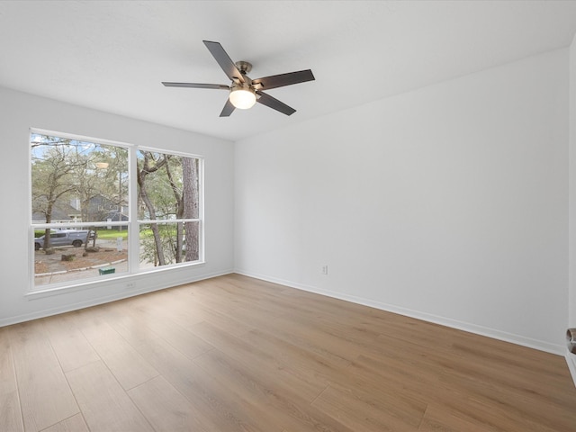 spare room with ceiling fan, baseboards, and wood finished floors