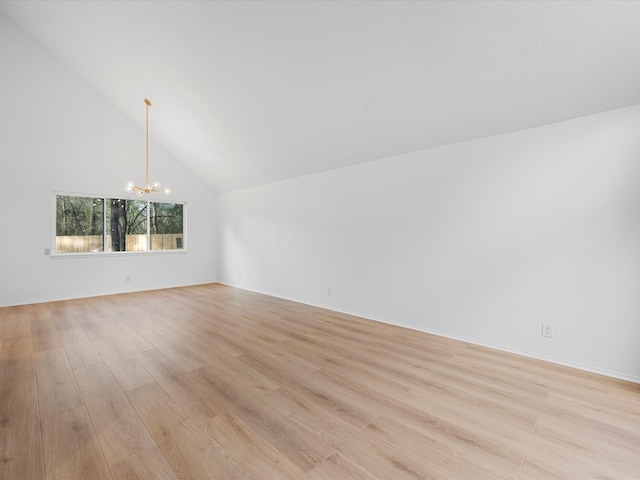 unfurnished room featuring light wood-style floors, a notable chandelier, and high vaulted ceiling