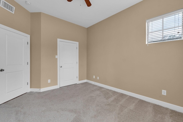 spare room featuring ceiling fan, carpet, visible vents, and baseboards