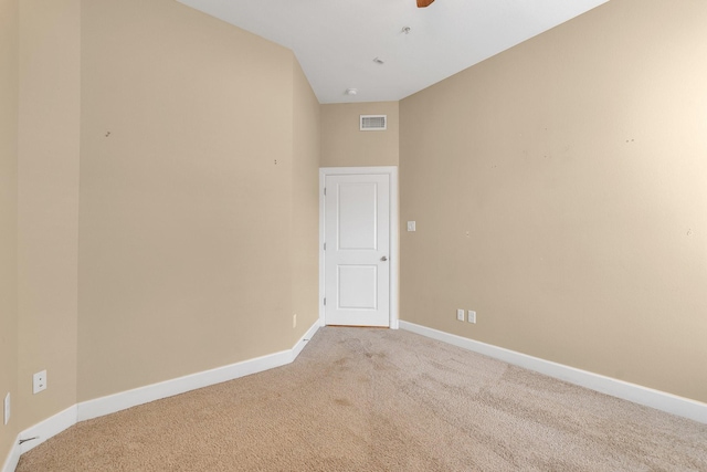 unfurnished room featuring baseboards, light carpet, visible vents, and ceiling fan