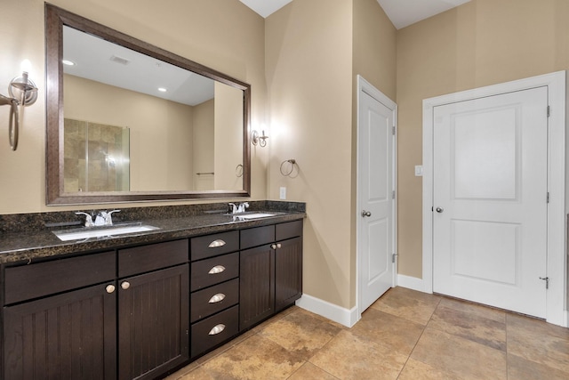 full bath featuring double vanity, baseboards, and a sink