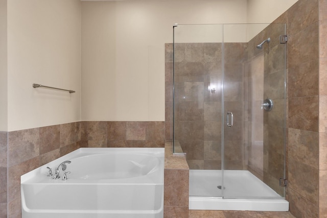 bathroom featuring a bath and a stall shower