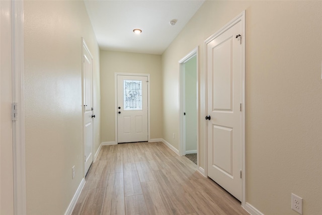 doorway to outside featuring light wood-style flooring and baseboards