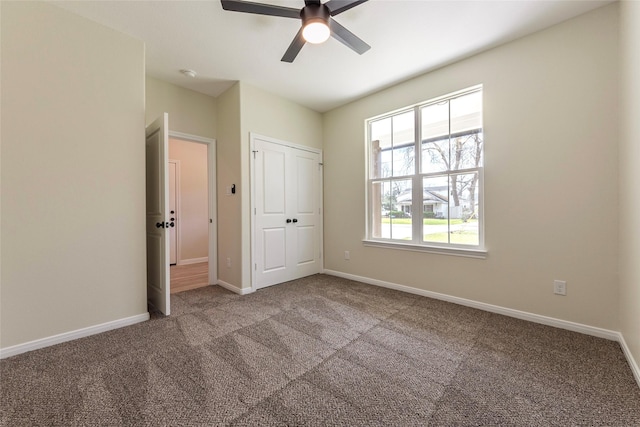 unfurnished bedroom with baseboards, carpet floors, a closet, and ceiling fan