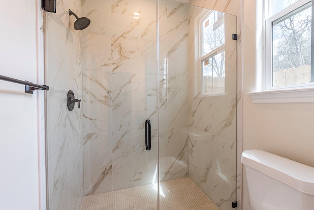 full bathroom featuring toilet and a marble finish shower