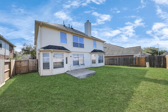 rear view of property featuring a lawn, a fenced backyard, and a chimney