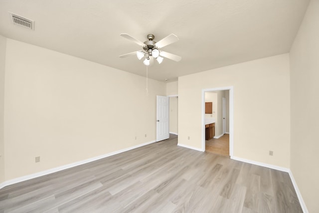 unfurnished bedroom featuring light wood finished floors, visible vents, ensuite bath, and baseboards