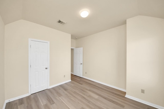 interior space featuring vaulted ceiling, light wood-style flooring, baseboards, and visible vents