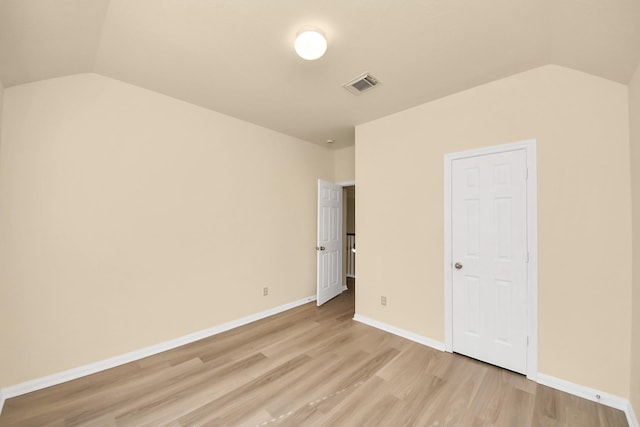 unfurnished bedroom featuring lofted ceiling, light wood-style flooring, baseboards, and visible vents