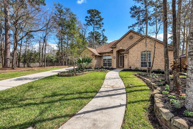 view of front of home with brick siding, a front lawn, and fence