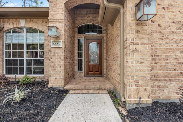 entrance to property featuring brick siding