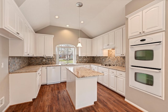 kitchen featuring white appliances, white cabinets, under cabinet range hood, and a sink