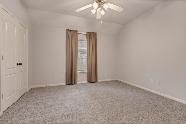 interior space featuring baseboards, lofted ceiling, carpet floors, and a ceiling fan