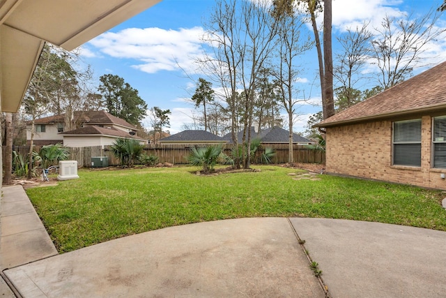 view of yard with central air condition unit, a fenced backyard, and a patio area