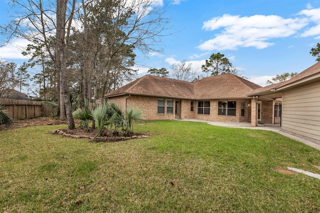 back of house with fence, a yard, a shingled roof, a patio area, and brick siding