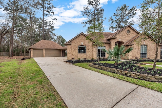 view of front of property with brick siding, a front lawn, fence, an outdoor structure, and driveway