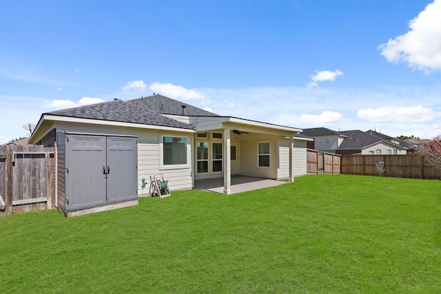 back of property featuring a fenced backyard, a shingled roof, ceiling fan, a patio area, and a lawn