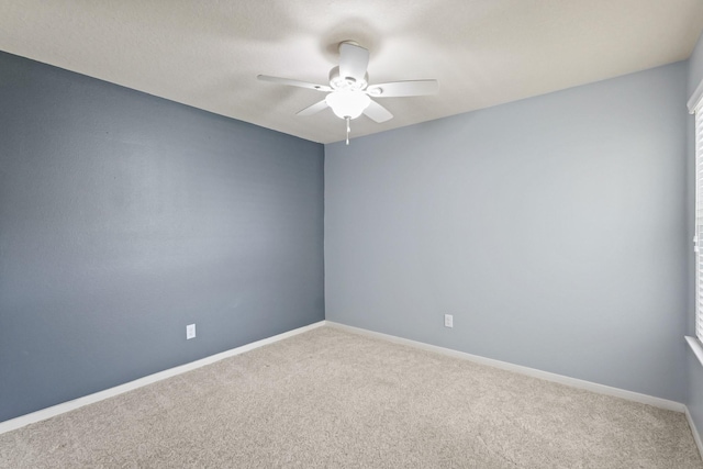 spare room with carpet flooring, baseboards, and ceiling fan