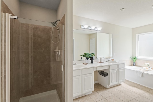 bathroom with a sink, a bath, a stall shower, and tile patterned flooring