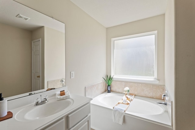 bathroom featuring visible vents, vanity, and a garden tub