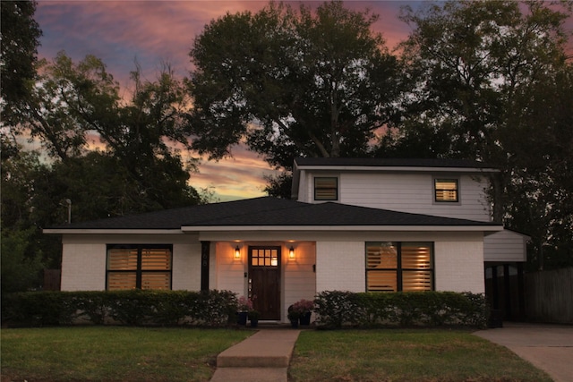 view of front of house featuring brick siding and a front yard