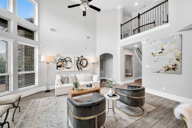 living room with visible vents, stairway, a ceiling fan, and wood finished floors