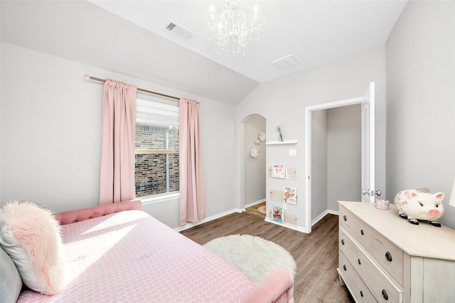 bedroom featuring visible vents, baseboards, a chandelier, vaulted ceiling, and light wood-style flooring