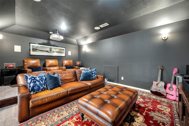 carpeted cinema room with vaulted ceiling, baseboards, and visible vents