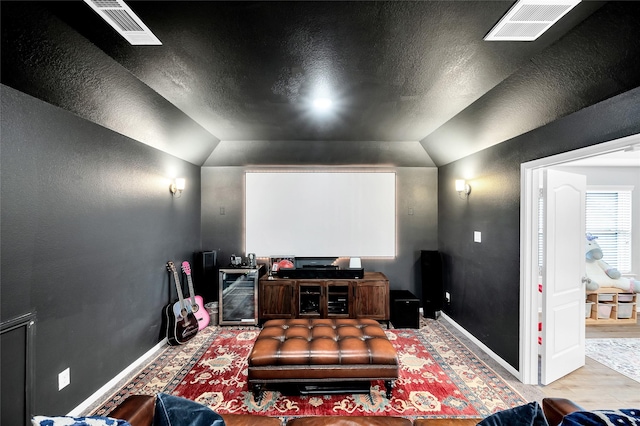 home theater room featuring beverage cooler, visible vents, and baseboards