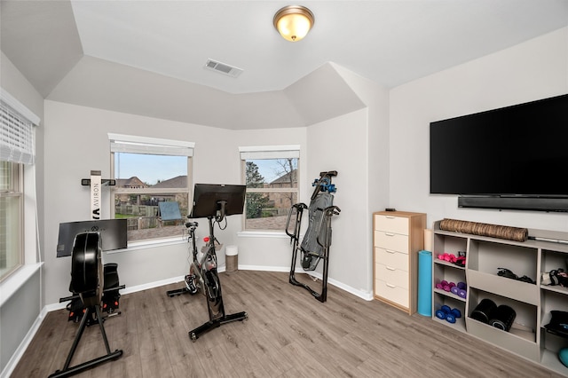 workout area featuring visible vents, baseboards, and wood finished floors