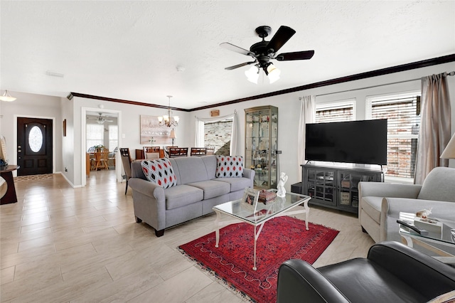 living area with crown molding, ceiling fan with notable chandelier, baseboards, and a textured ceiling