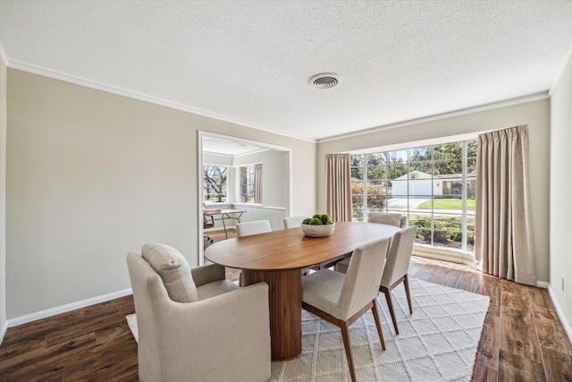 dining space with plenty of natural light, wood finished floors, visible vents, and ornamental molding