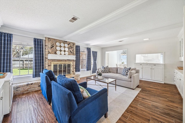 living area with visible vents, baseboards, a fireplace, dark wood-style floors, and a textured ceiling