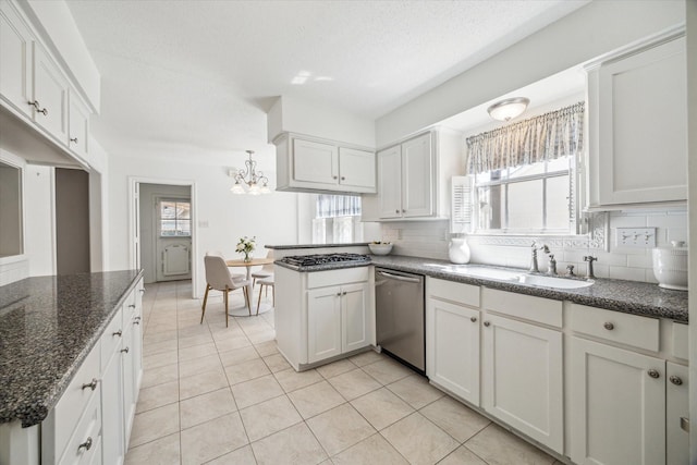 kitchen with decorative backsplash, dishwasher, a peninsula, and a sink