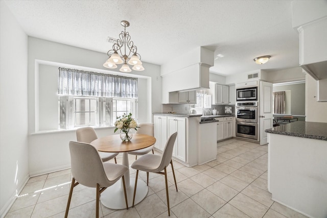 dining area featuring a chandelier, a healthy amount of sunlight, light tile patterned flooring, and visible vents