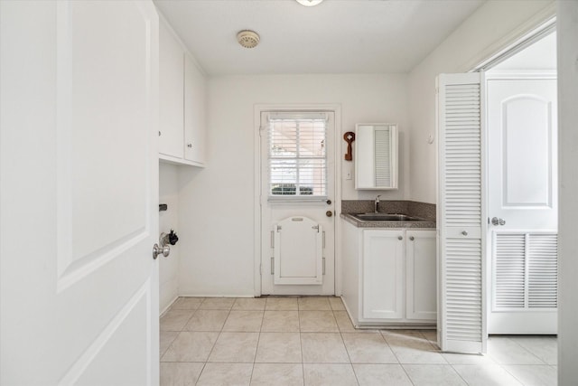 laundry area featuring a sink, visible vents, and light tile patterned flooring