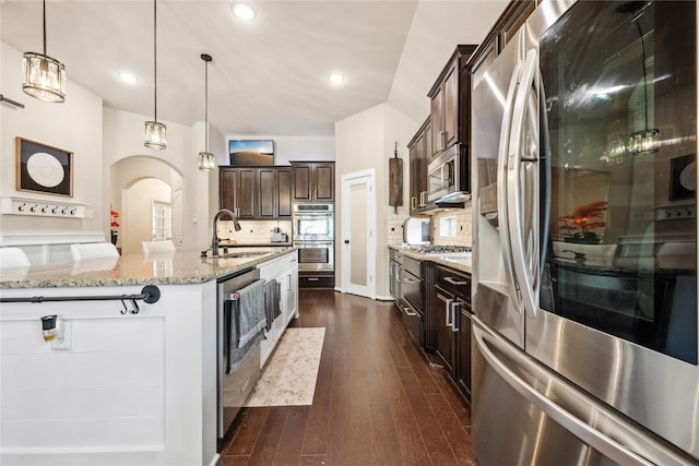 kitchen featuring decorative backsplash, dark wood-style floors, appliances with stainless steel finishes, and a sink