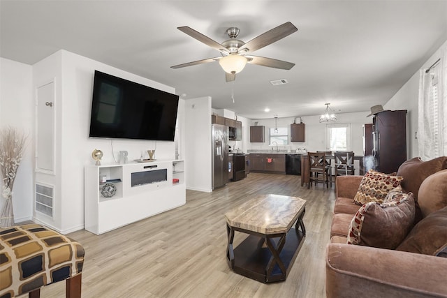 2000 Rosalee St, La Marque, TX 77568 - living room with a ceiling fan, light wood finished floors, a chandelier, and baseboards