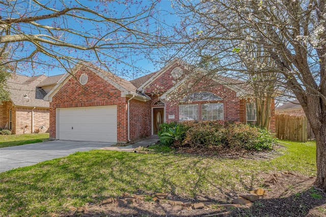 view of front facade featuring a front yard, fence, driveway, an attached garage, and brick siding