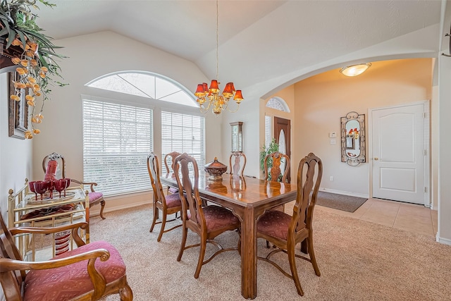 dining room featuring light tile patterned floors, arched walkways, vaulted ceiling, a notable chandelier, and light colored carpet