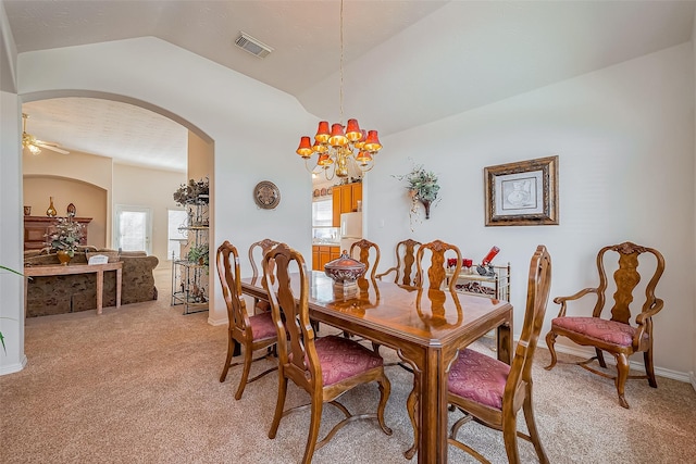 dining room with arched walkways, visible vents, a healthy amount of sunlight, and light carpet